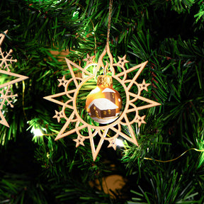 Holzstern mit Weihnachtskugel am Baum
